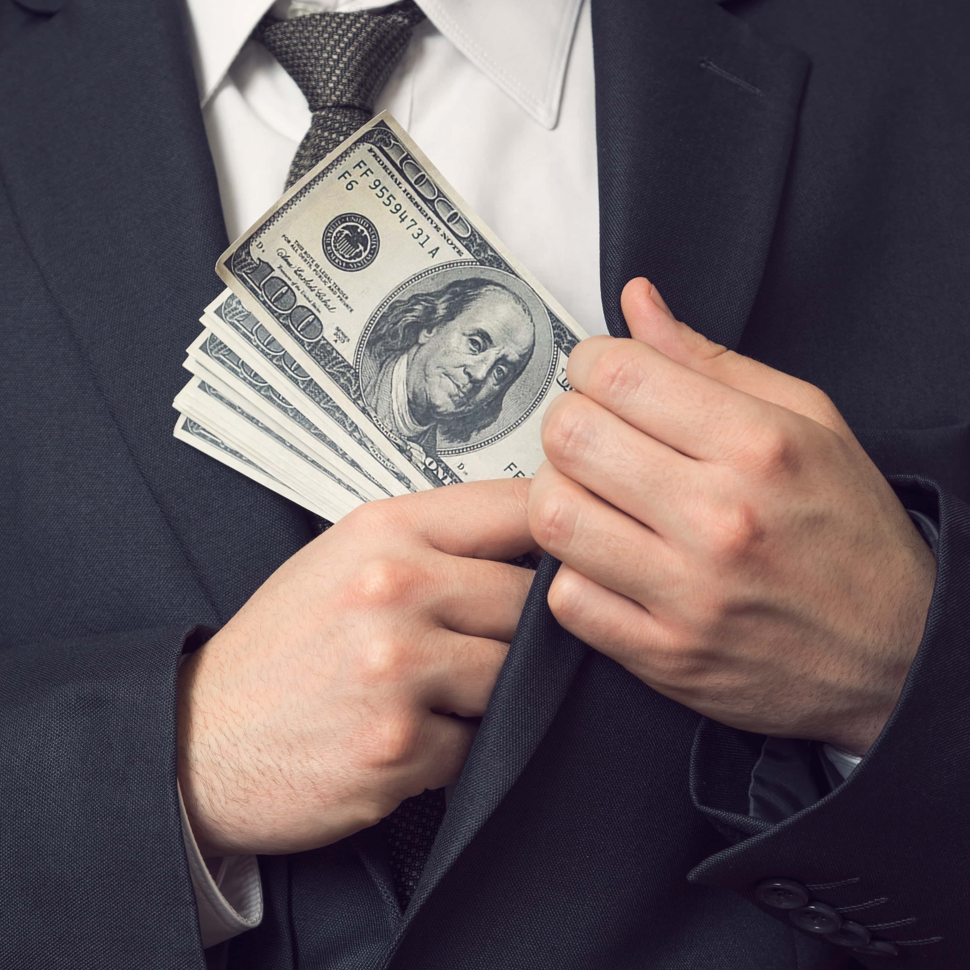 Profesional en hipotecas de Cádiz explicando ventajas a una joven pareja, con planos de vivienda y simulador hipotecario